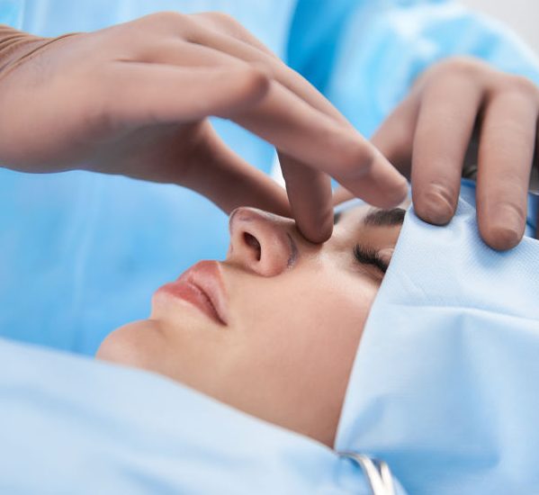 Close up photo of doctor hands palpating nose before operation
